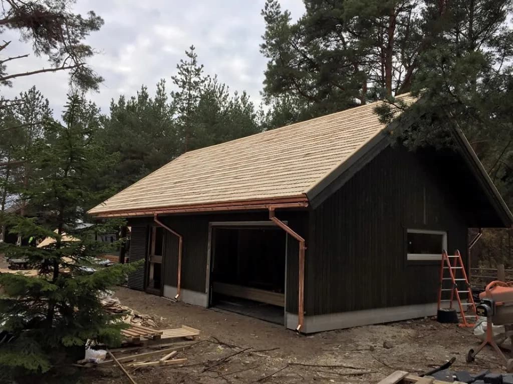 Naissaare tumepuidust hoone värske laastukatuse ja vasest vihmaveesüsteemiga