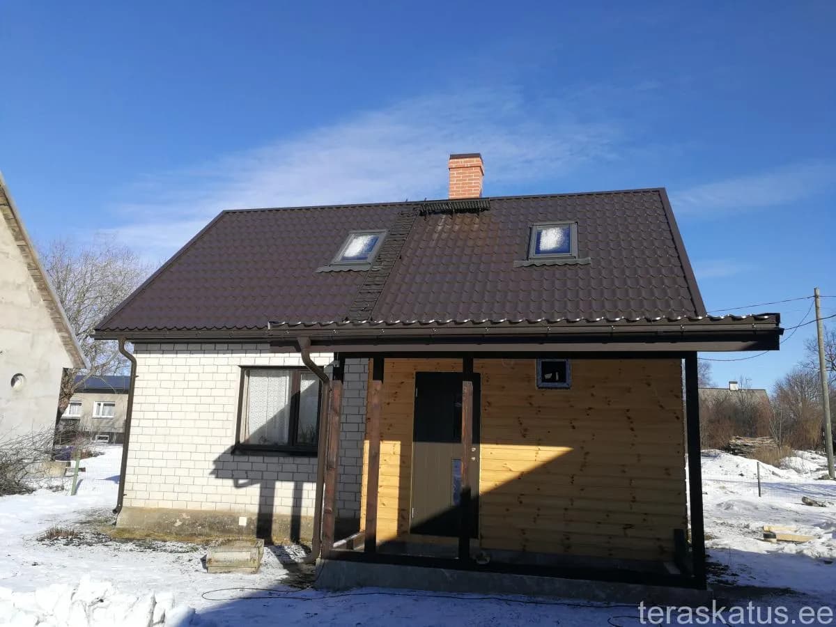 Pruun tellisprofiiliga plekk-katus kahe katuseakna ja telliskorstnaga, puitvarikatus ehitusjärgus